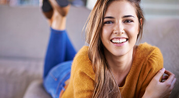 woman laying on couch smiling