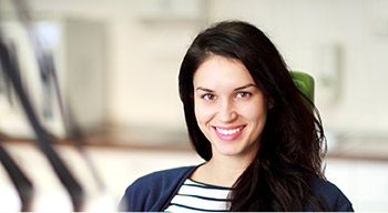 woman sitting in green exam chair